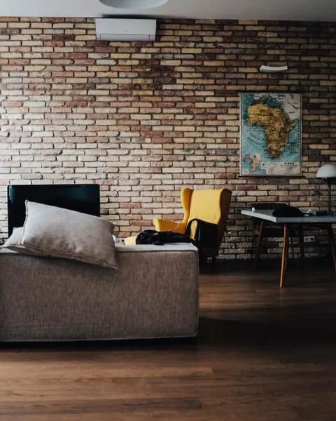 Loft-Wohnzimmer mit Backsteinwand, Sofa und Sessel