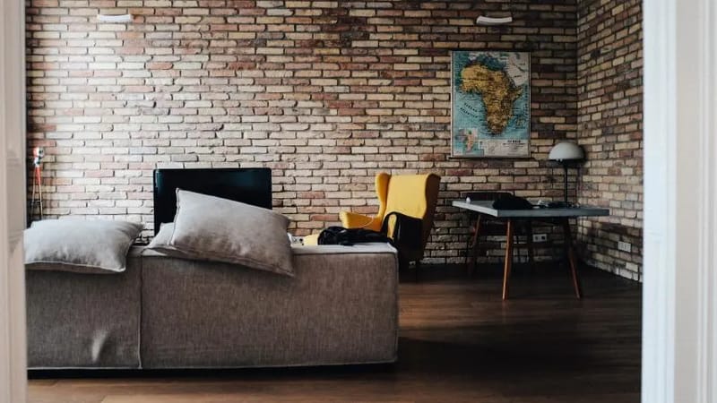 Loft-Wohnzimmer mit Backsteinwand, Sofa und Sessel