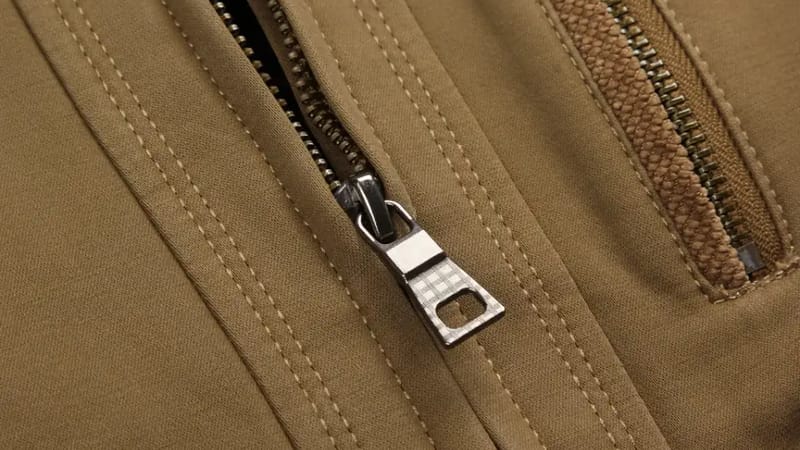Reißverschluss an einer beigen Jacke