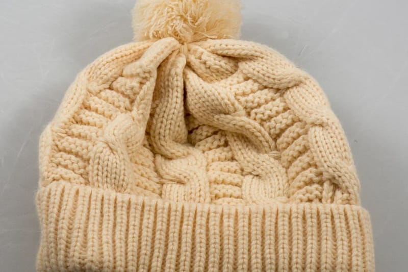 Cream cable-knit hat with pompom