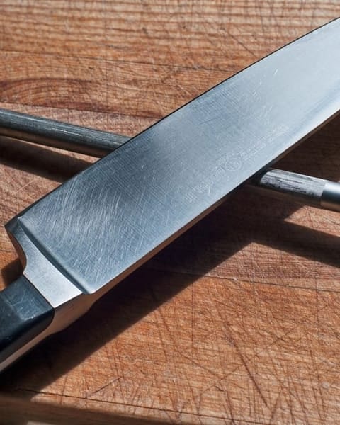 Kochmesser und Wetzstahl auf einem Holzbrett