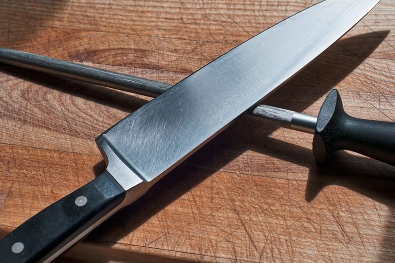 Chef's knife and honing steel on a wooden board