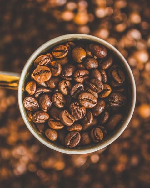 Mug full of roasted coffee beans