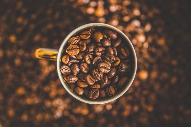 Becher voller gerösteter Kaffeebohnen