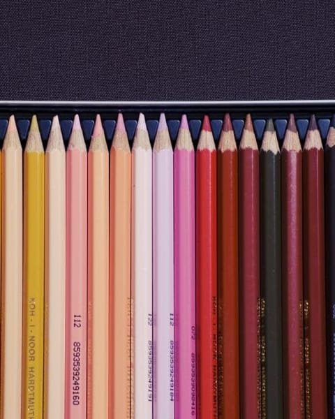 Coloured pencils in a metal tin