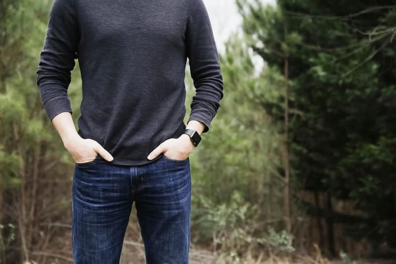 Mann in dunklem Sweatshirt im Wald