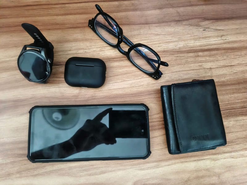Ladecase, Brille, Smartphone und Geldbörse auf Holz