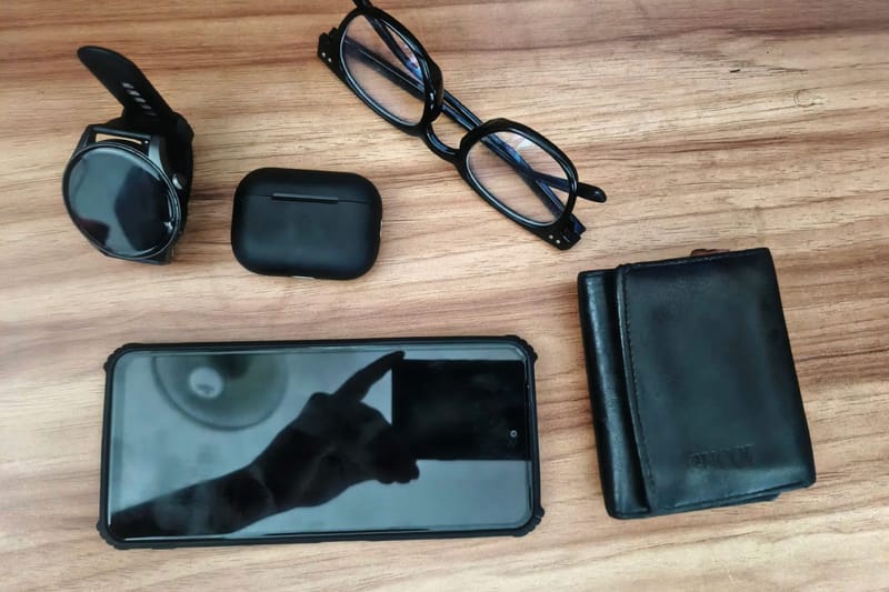 Ladecase, Brille, Smartphone und Geldbörse auf Holz