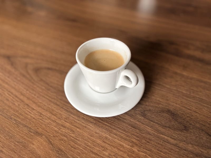 Weiße Espressotasse auf Holz