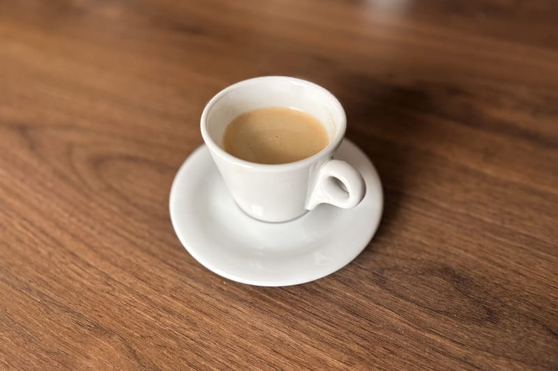 Weiße Espressotasse auf Holz