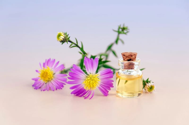 Kleine Ölflasche mit Korken neben Blüten