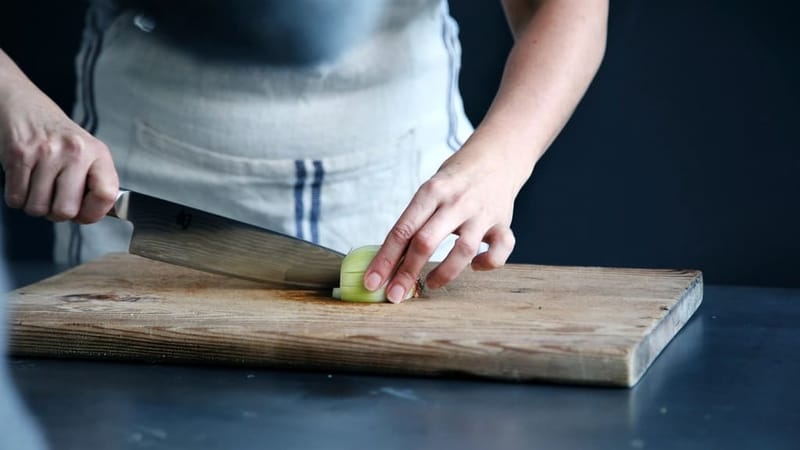 Person cutting with the chef's knife on a board