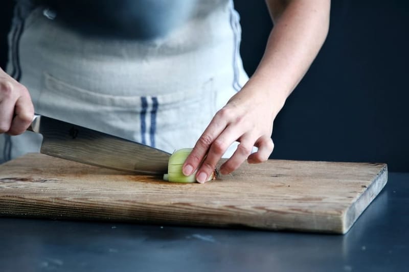 Person cutting with the chef's knife on a board