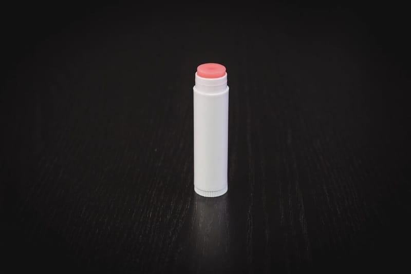 Lip balm stick on dark wood