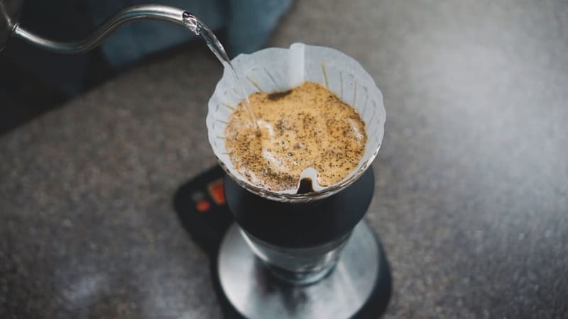 Water poured from the kettle onto coffee