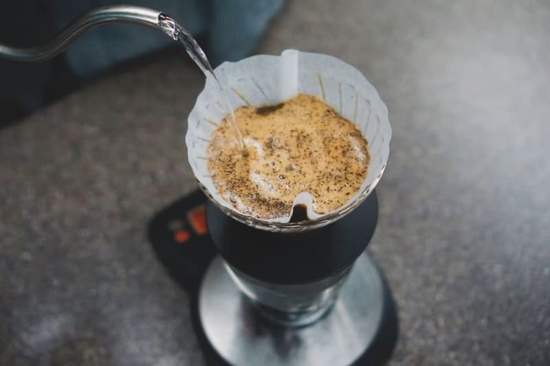 Water poured from the kettle onto coffee