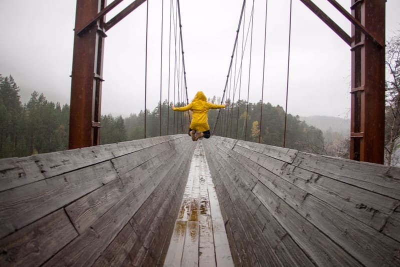 Yellow rain jacket on a suspension bridge in the rain