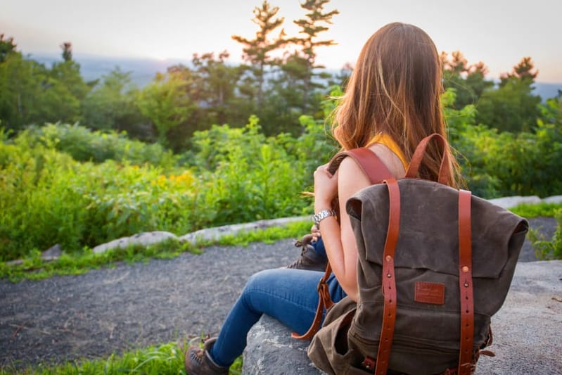 Frau mit grauem Canvas-Rucksack auf einem Wanderweg