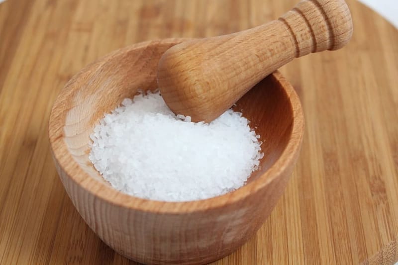 Salt flakes in a wooden mortar