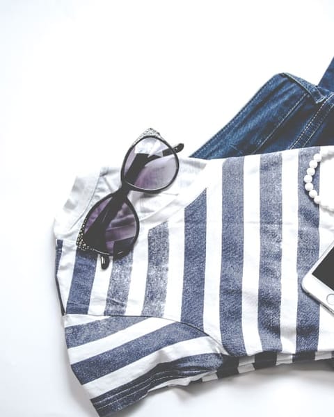 Gestreiftes Shirt mit Jeans, Sonnenbrille und Smartphone als Flatlay