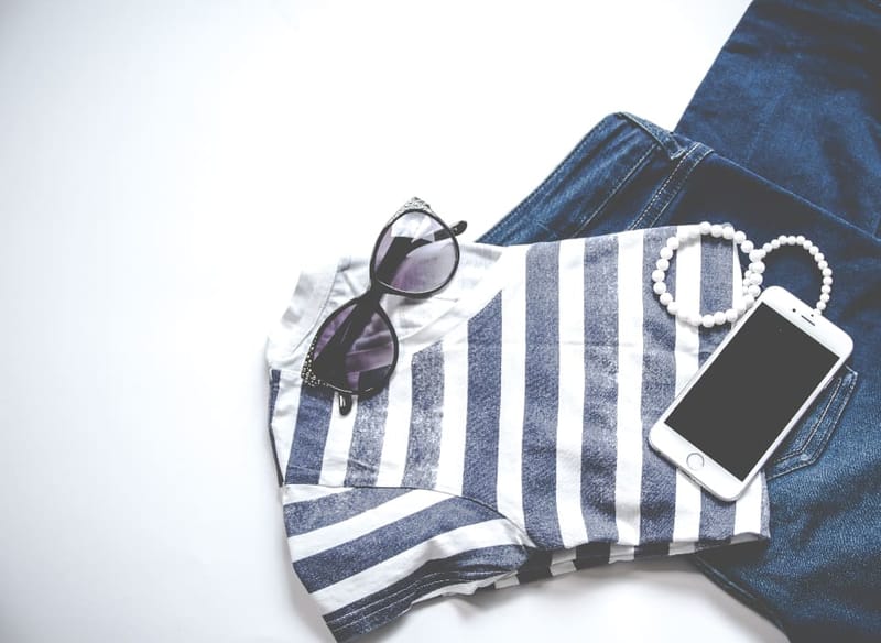 Gestreiftes Shirt mit Jeans, Sonnenbrille und Smartphone als Flatlay