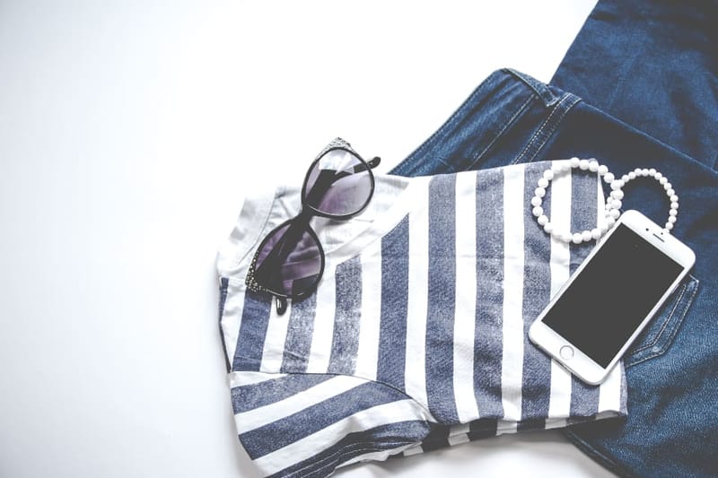Gestreiftes Shirt mit Jeans, Sonnenbrille und Smartphone als Flatlay