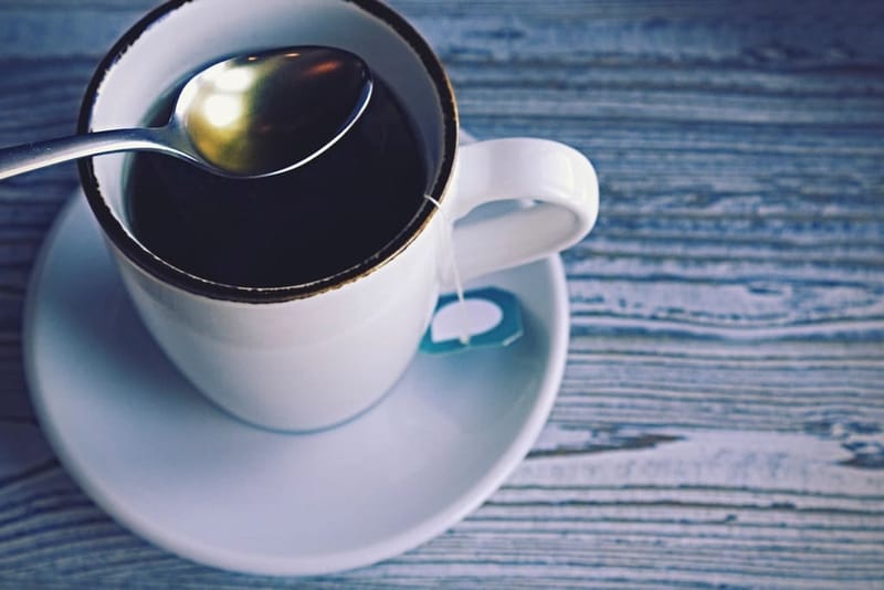 Cup of tea with a spoon on blue wood