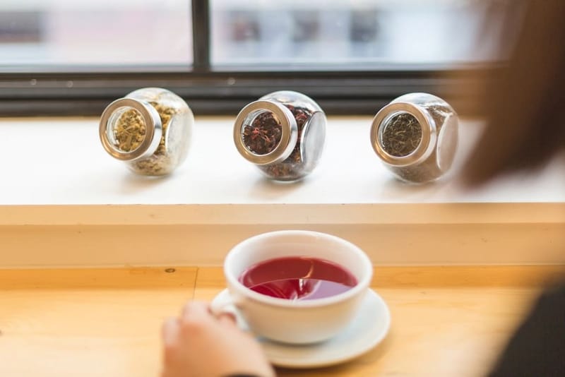 Tea tins on a window sill with a cup of tea