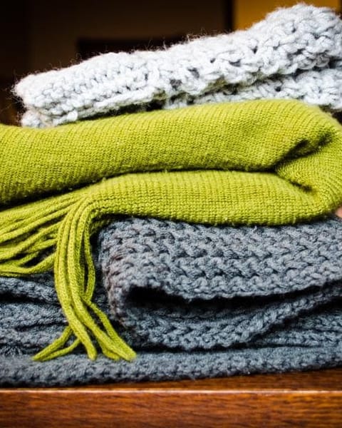 Stacked wool throws in green and grey
