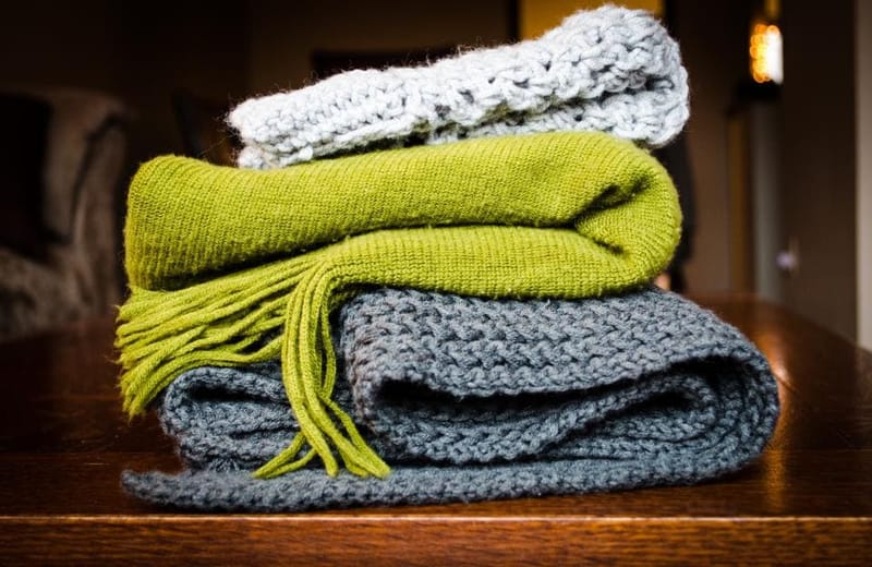 Stacked wool throws in green and grey