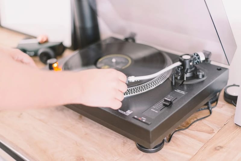 Hand placing the tonearm on a record