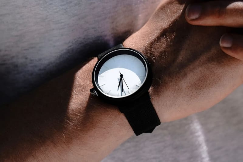 Black watch with white dial on a wrist